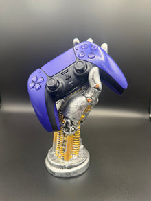 Galactic Purple PS5 DualSense unit PS5-GPR-001 displayed on a silver robotic hand controller stand