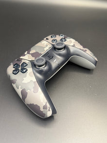 Left-front angled view of Gray Camouflage PS5 DualSense unit PS5-CMO-002 showing the D-pad and left grip